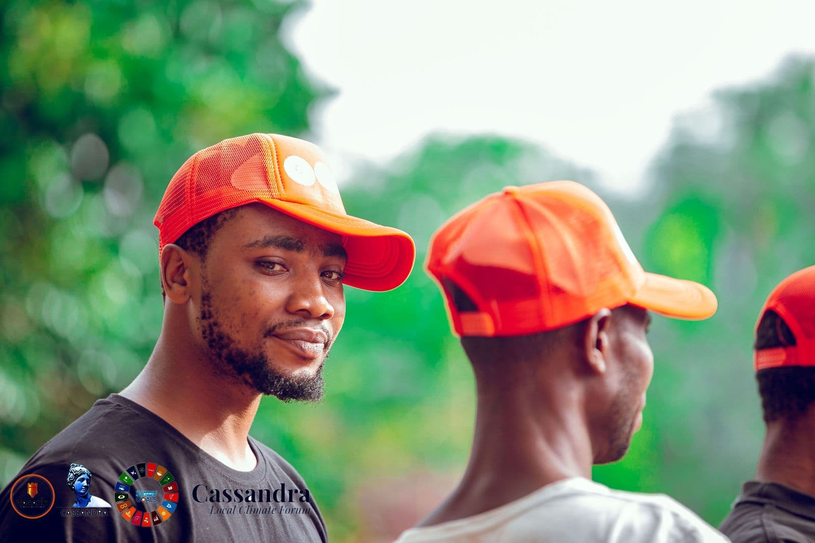 Two volunteers in orange caps smile during the erosion-control work