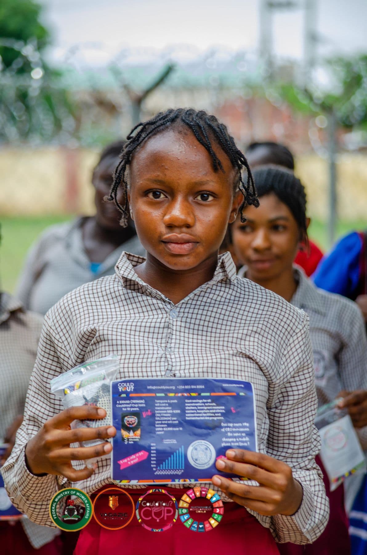 A schoolgirl holds up an information card