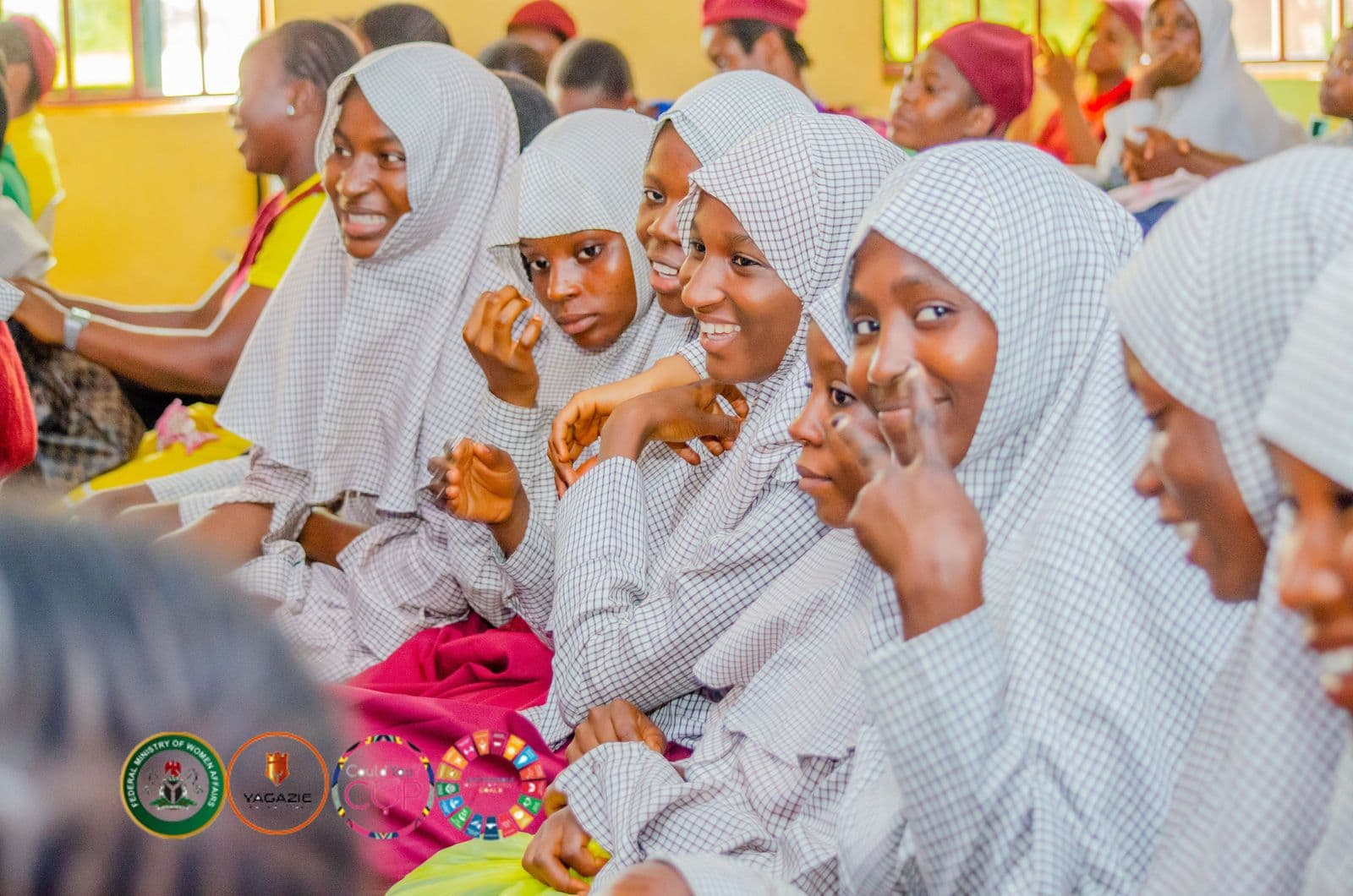 Girls in hijabs laugh together during the awareness session