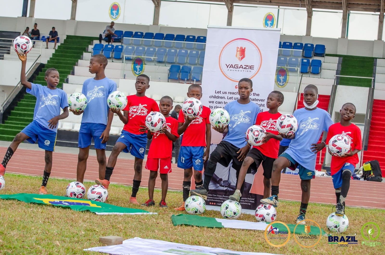 Young campers pose with their mentors in front of the Yagazie Foundation banner