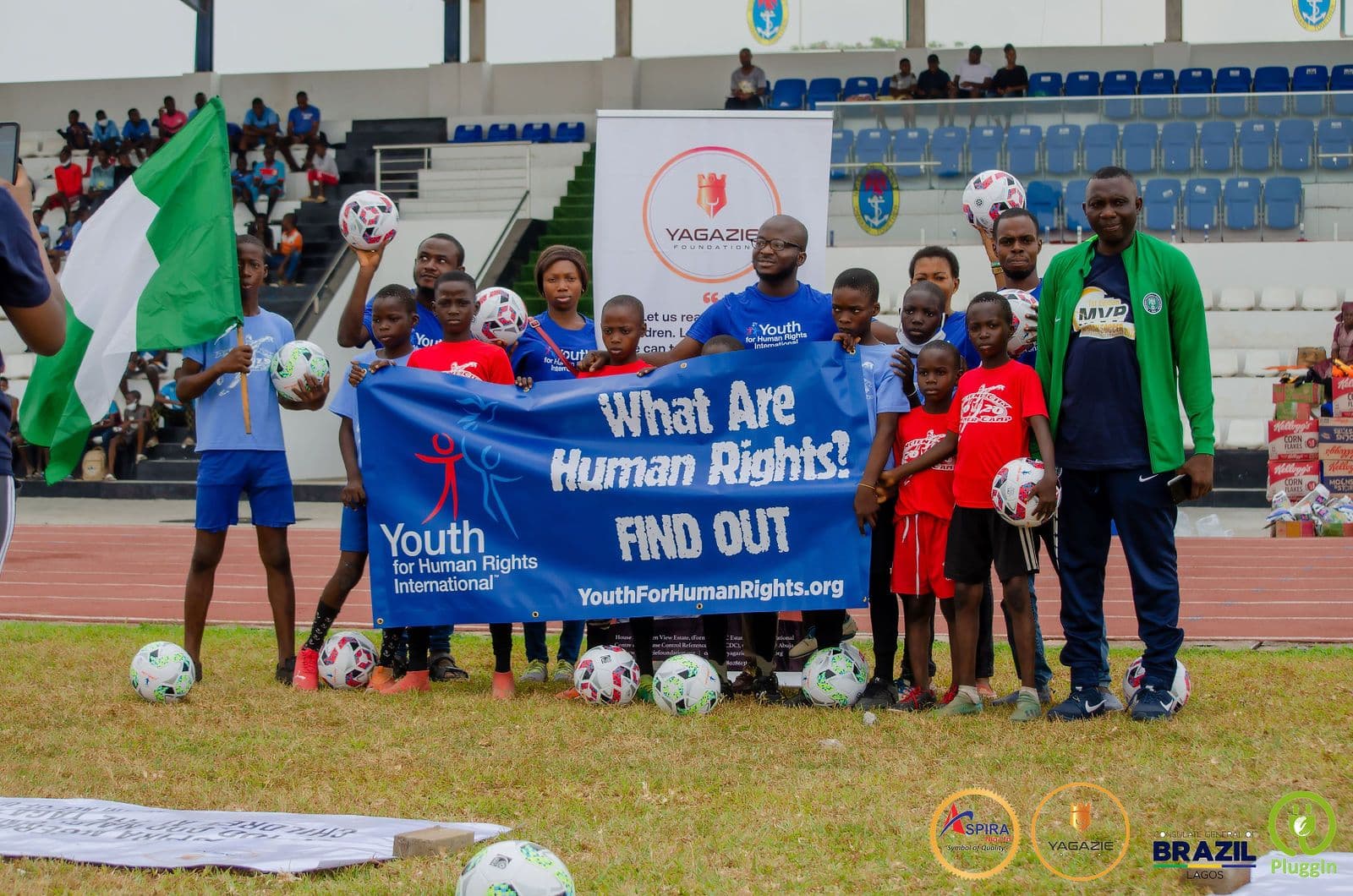 Campers and mentors hold a 'What Are Human Rights? Find Out' banner from Youth for Human Rights International