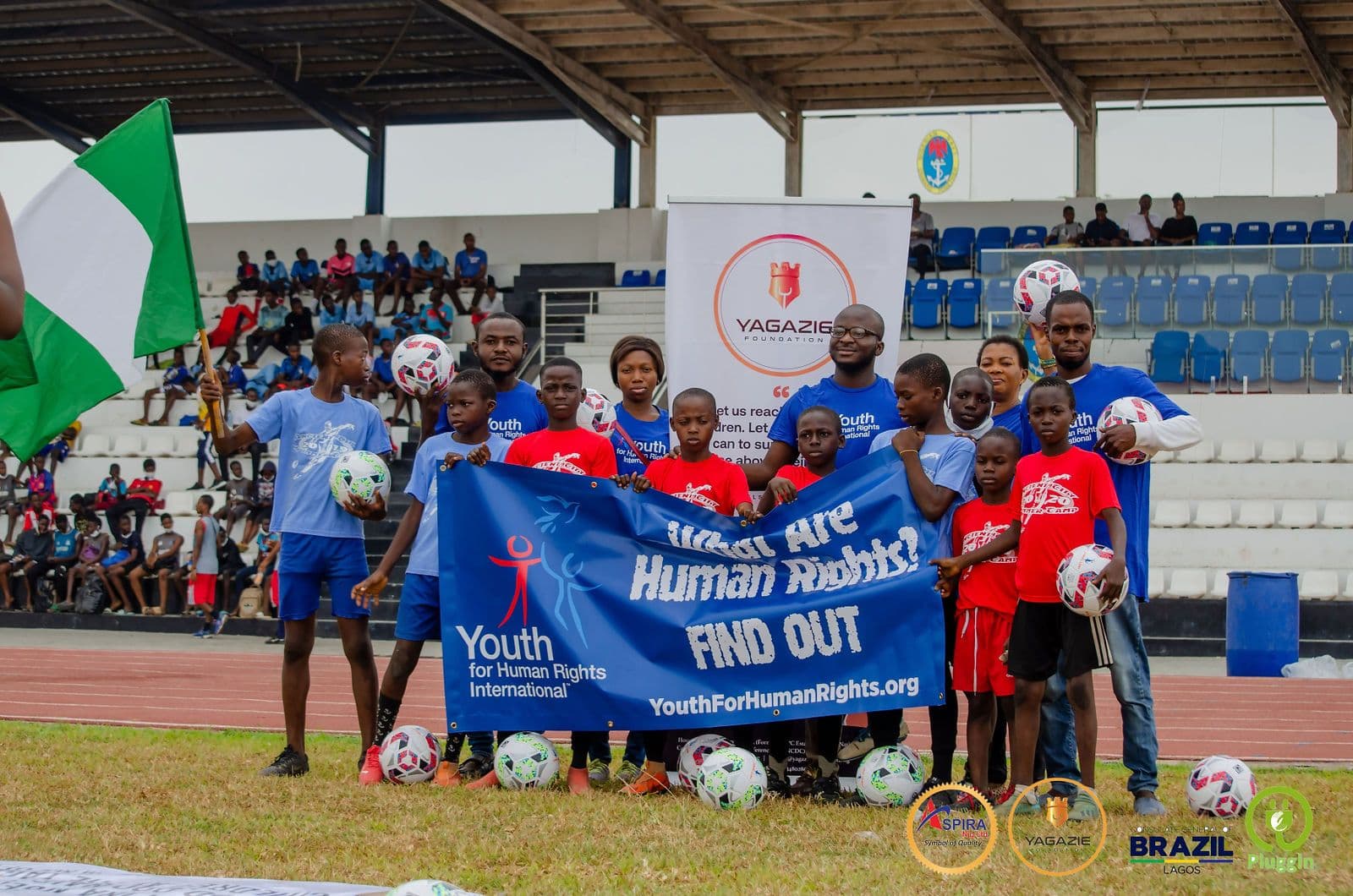 Young campers and mentors with the Youth for Human Rights banner and Nigerian flags