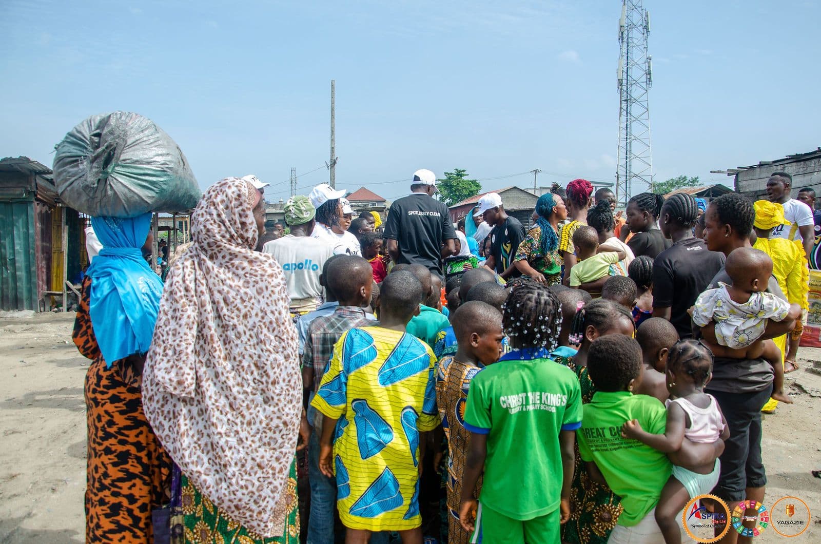 Families queue on a street in Ajegunle